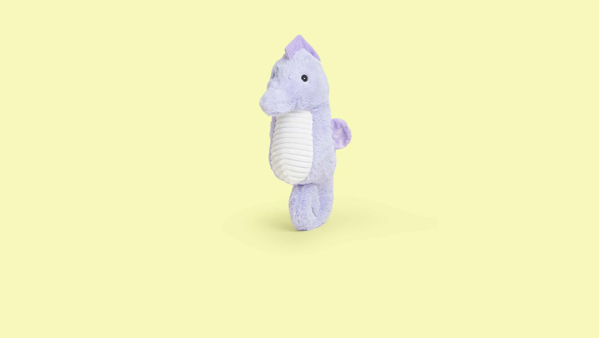 Image with a light pink background featuring a Starfish Warmies and a Shark Warmies.